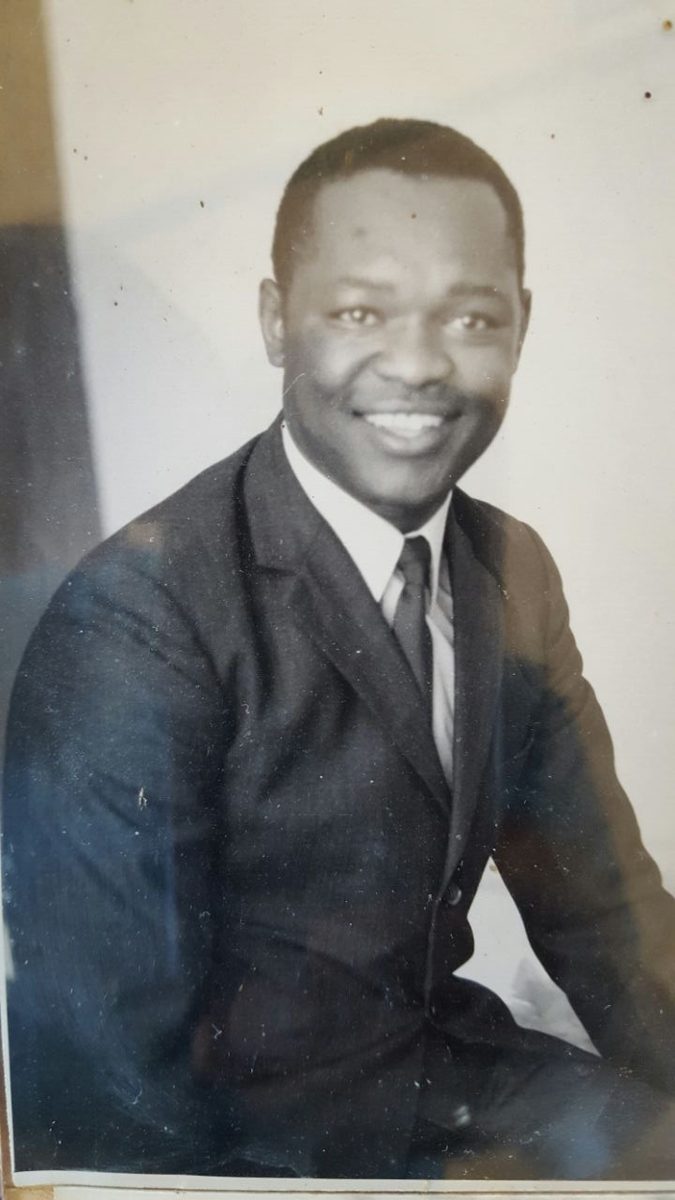 Black and white portrait of a smiling young man in a suit and tie